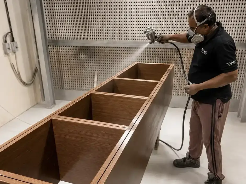 Spray-booth lacquering of a bespoke veneered unit at the Divano factory