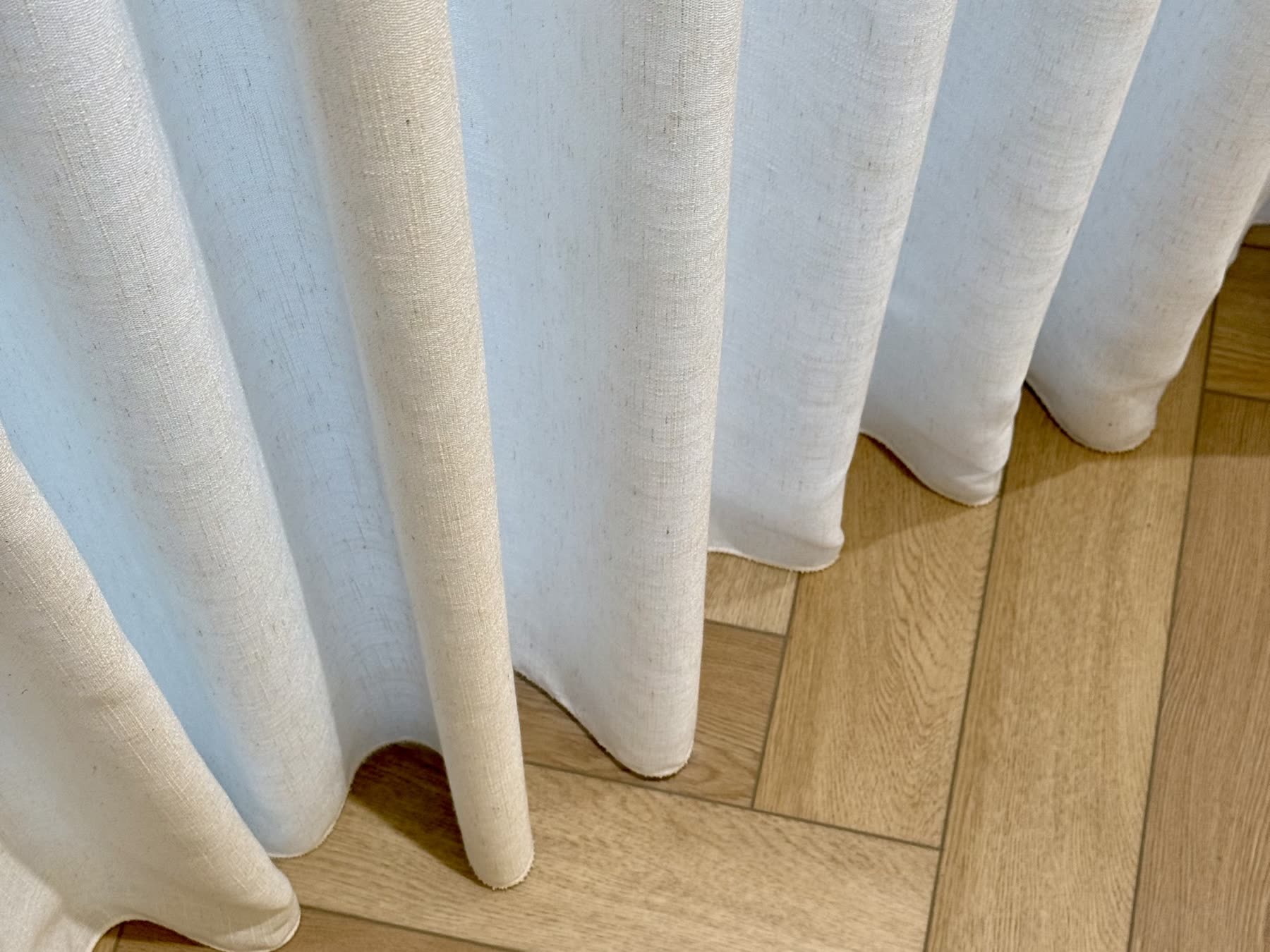 Curtains & Wallpapers by Divano - linen curtains breaking on a herringbone oak floor